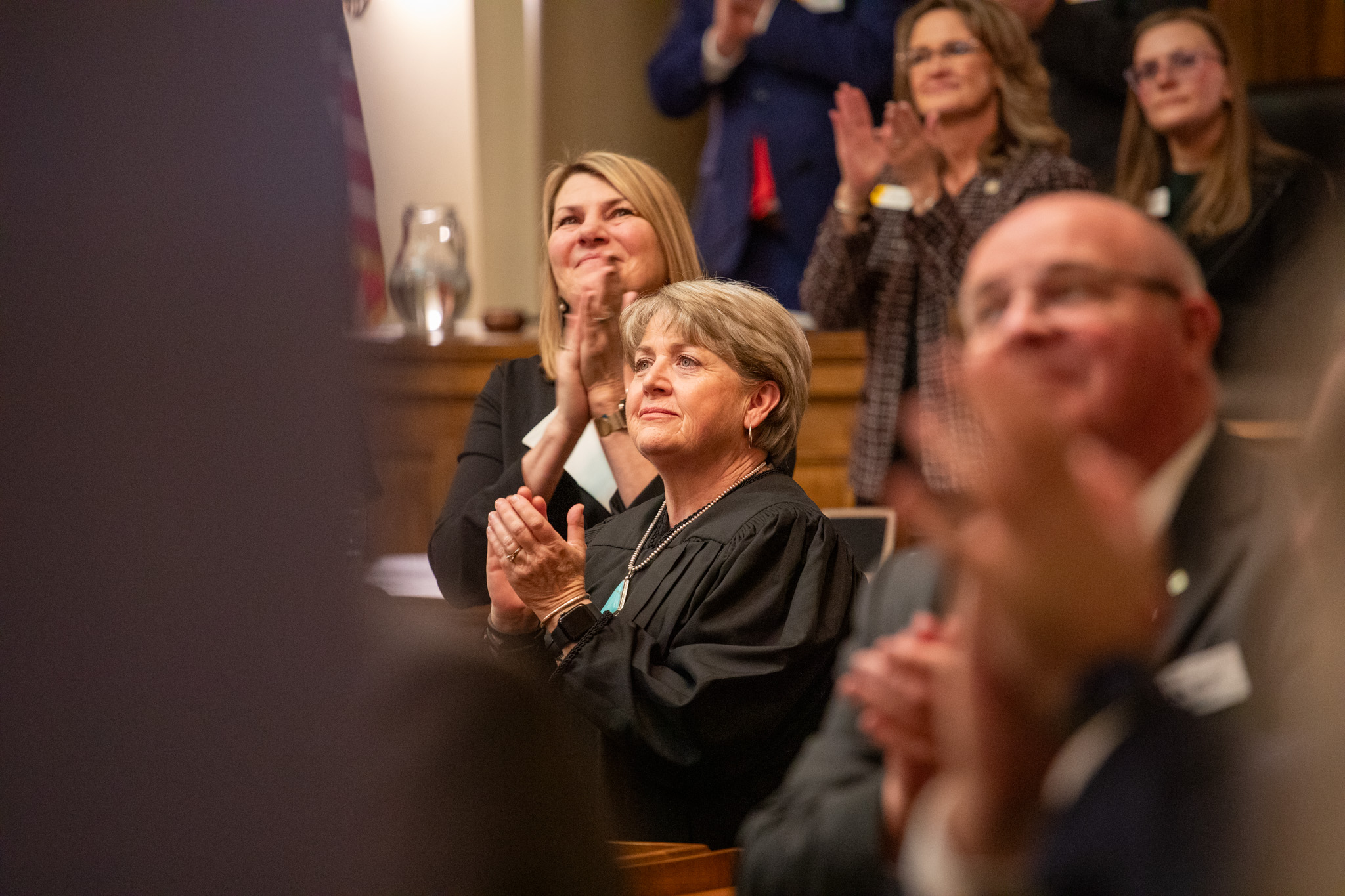 A group of people looking up and clapping.